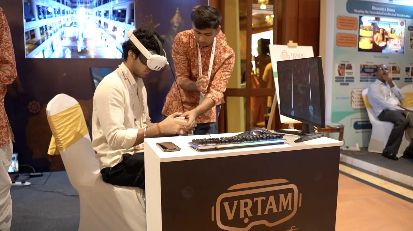 Vṛtam’s VR booth at the Swarajya Conclave: a visitor in a headset exploring an immersive environment while the team assists